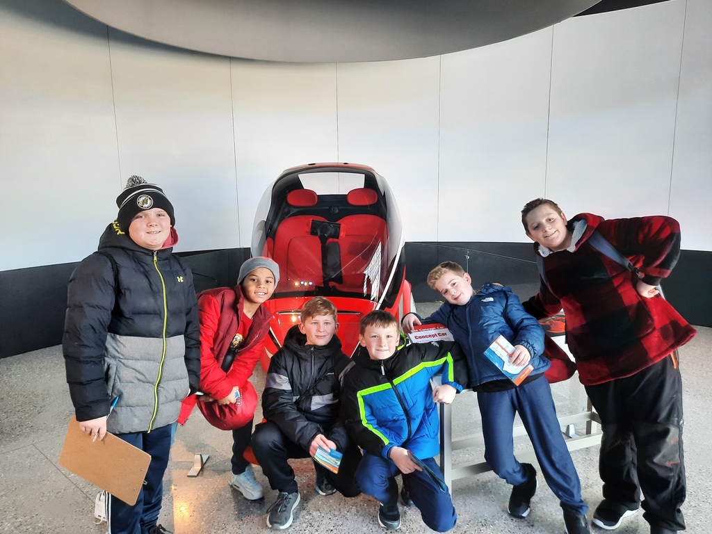 Picture of students in front of car